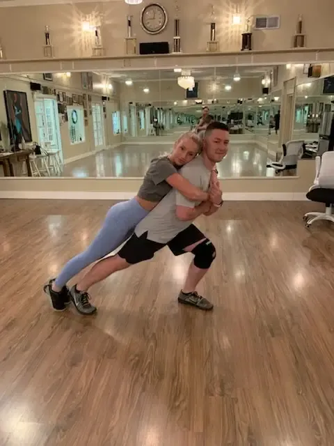 A couple in a low lunge during a studio lesson