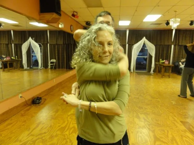 A dance instructor leading a group through a step